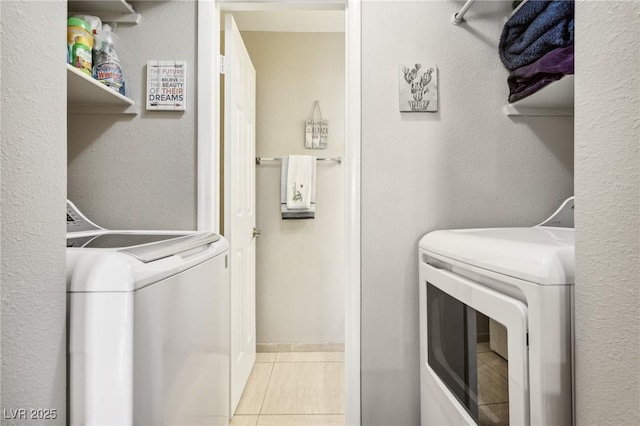 laundry room with washing machine and clothes dryer, tile patterned floors, and laundry area
