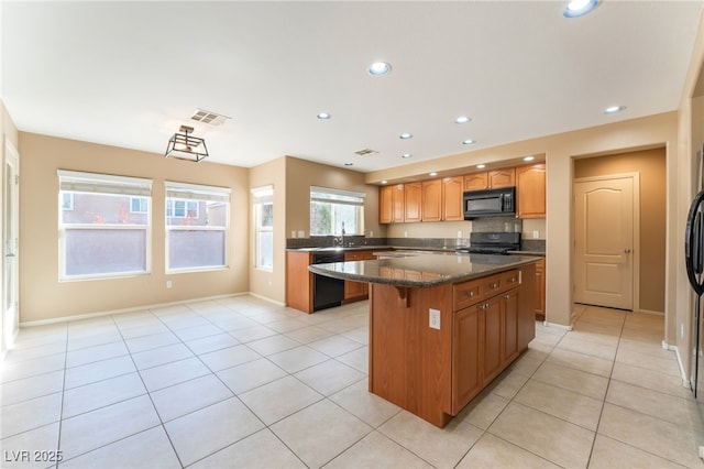 kitchen with light tile patterned flooring, a center island, recessed lighting, visible vents, and black appliances