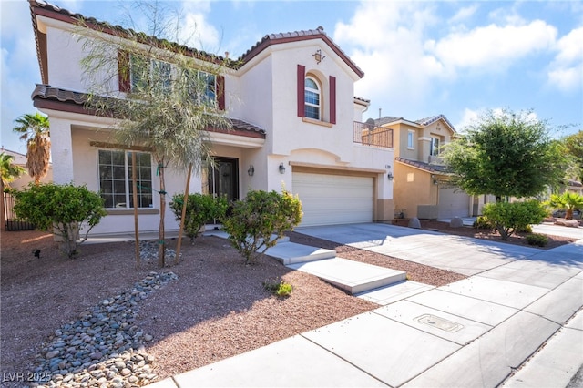 mediterranean / spanish-style home with stucco siding, driveway, a tile roof, and a garage