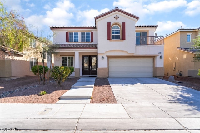 mediterranean / spanish house with a tiled roof, stucco siding, and french doors