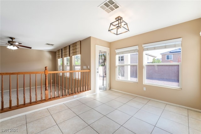 unfurnished room featuring visible vents, a ceiling fan, baseboards, and light tile patterned flooring