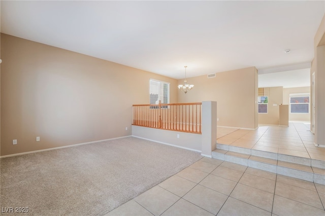 spare room with an inviting chandelier, light tile patterned floors, baseboards, and visible vents