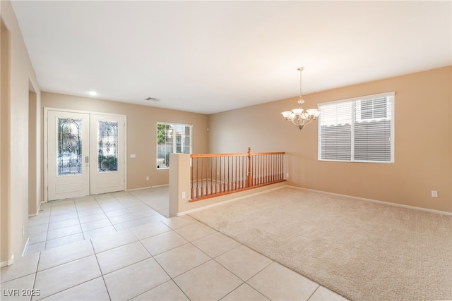 foyer with visible vents, baseboards, light colored carpet, a chandelier, and light tile patterned floors