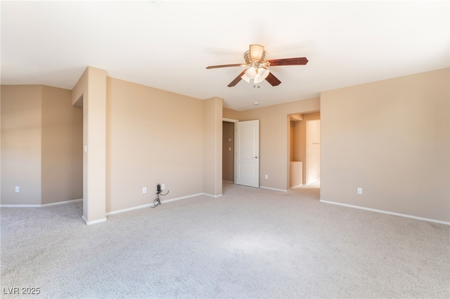 spare room featuring a ceiling fan, baseboards, and light colored carpet