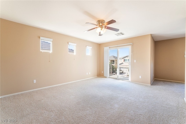 spare room with baseboards, ceiling fan, light carpet, and visible vents