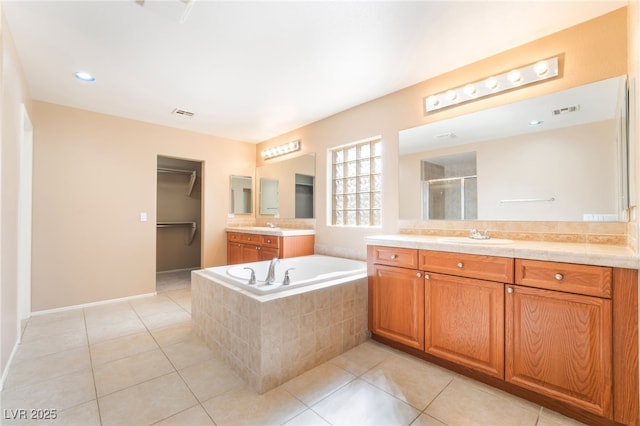 bathroom featuring a garden tub, visible vents, tile patterned flooring, a shower stall, and a sink