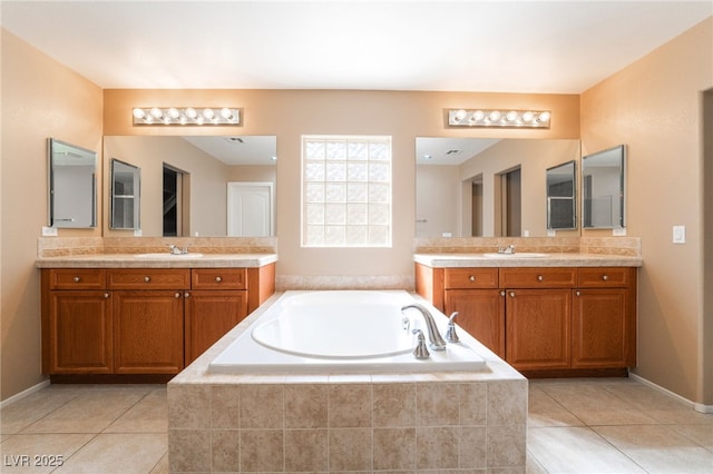 bathroom with tile patterned floors, two vanities, a sink, and a garden tub