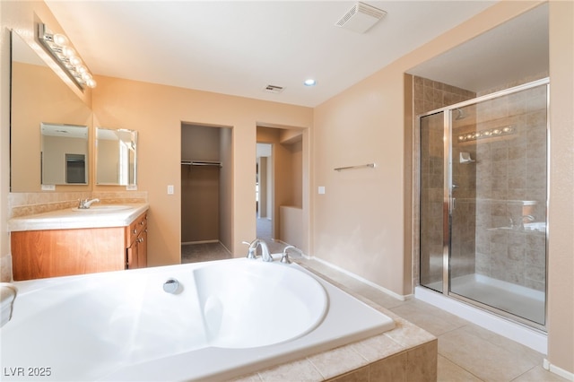 bathroom with vanity, a stall shower, a garden tub, and visible vents