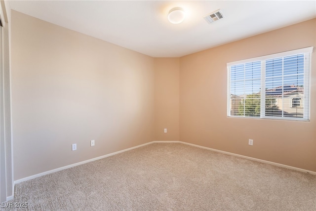 spare room featuring visible vents, carpet flooring, and baseboards