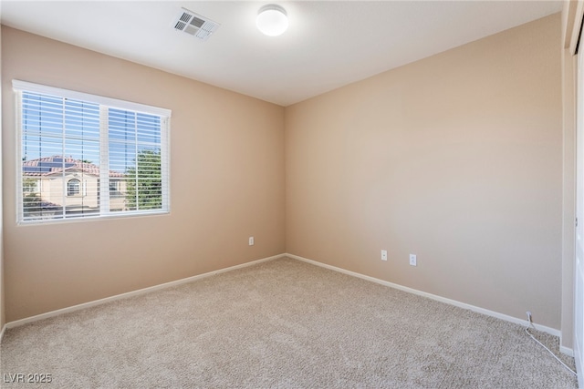 spare room with baseboards, visible vents, and carpet