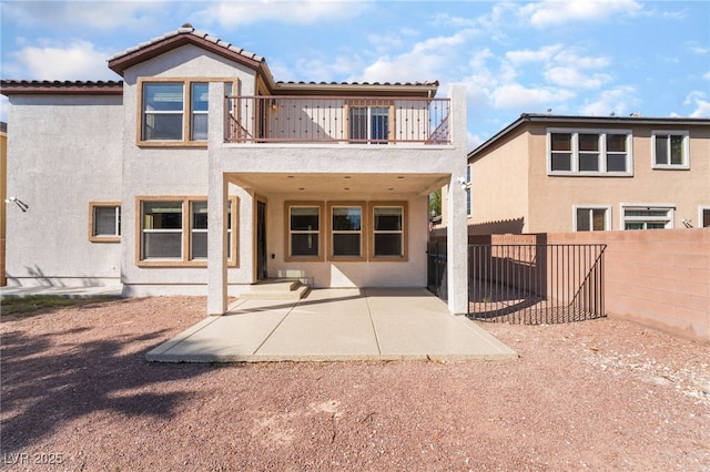 back of property featuring a patio area, a balcony, a fenced backyard, and stucco siding