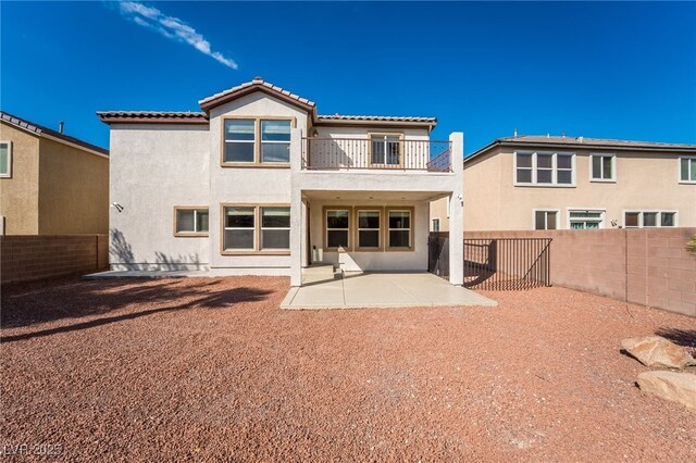 7098 Seabirds Pl, North Las Vegas, NV 89084 - rear view of property featuring a balcony, a tile roof, stucco siding, a patio, and a fenced backyard