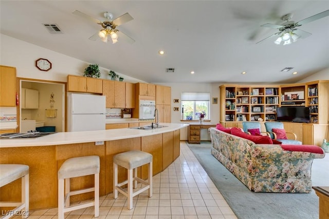 kitchen with white appliances, a ceiling fan, lofted ceiling, and light countertops
