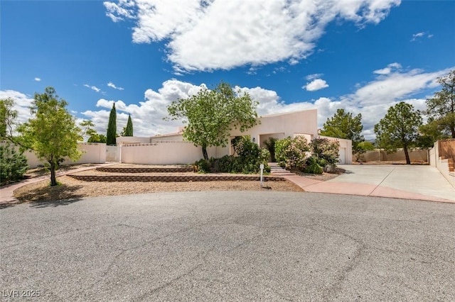 exterior space featuring fence, stucco siding, driveway, and a garage