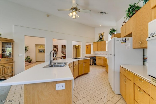 kitchen featuring a ceiling fan, visible vents, a center island with sink, a sink, and light countertops