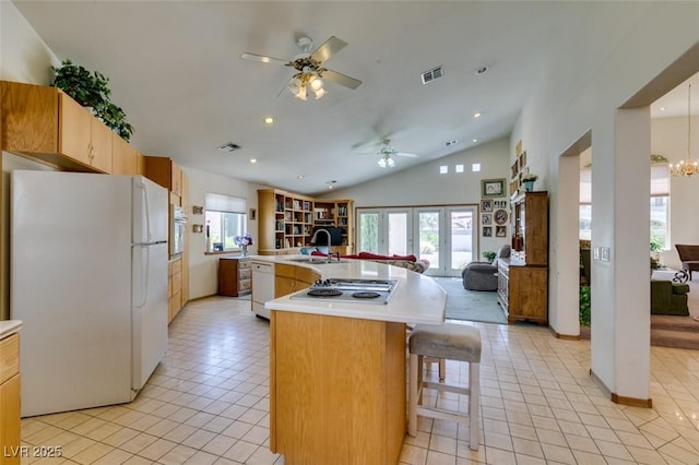 kitchen featuring open floor plan, ceiling fan with notable chandelier, light tile patterned floors, and white appliances