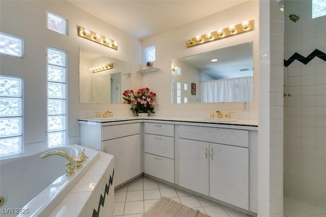 full bathroom with tile patterned floors, walk in shower, a bath, and vanity