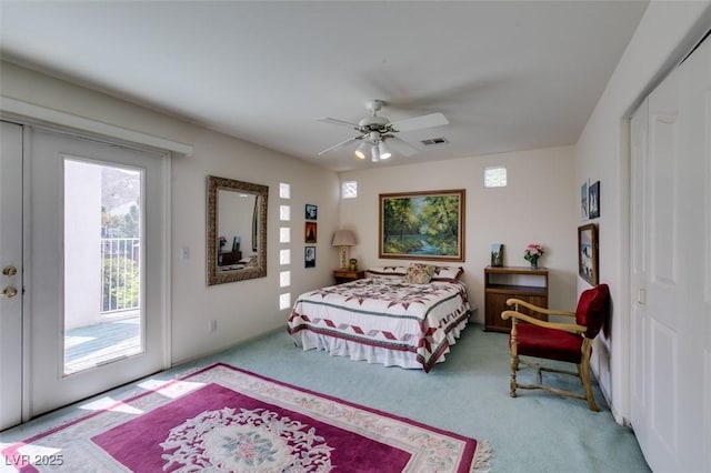 carpeted bedroom with access to outside, a ceiling fan, and visible vents