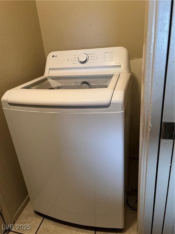 clothes washing area with a textured wall and washer / dryer