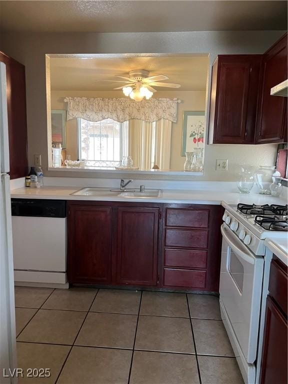 kitchen with light tile patterned flooring, a sink, white appliances, light countertops, and a ceiling fan