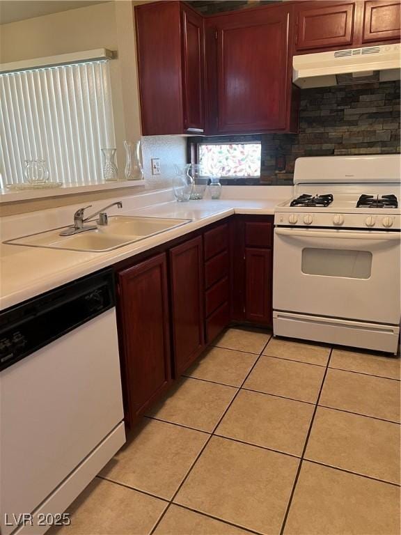 kitchen with light tile patterned flooring, white appliances, light countertops, backsplash, and under cabinet range hood