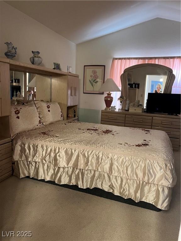carpeted bedroom featuring lofted ceiling