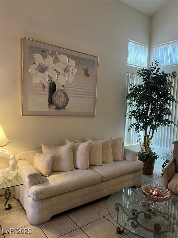 tiled living area featuring a towering ceiling