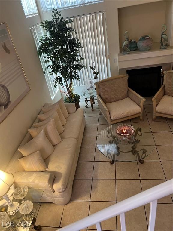 living room featuring tile patterned flooring, a fireplace, and a wealth of natural light