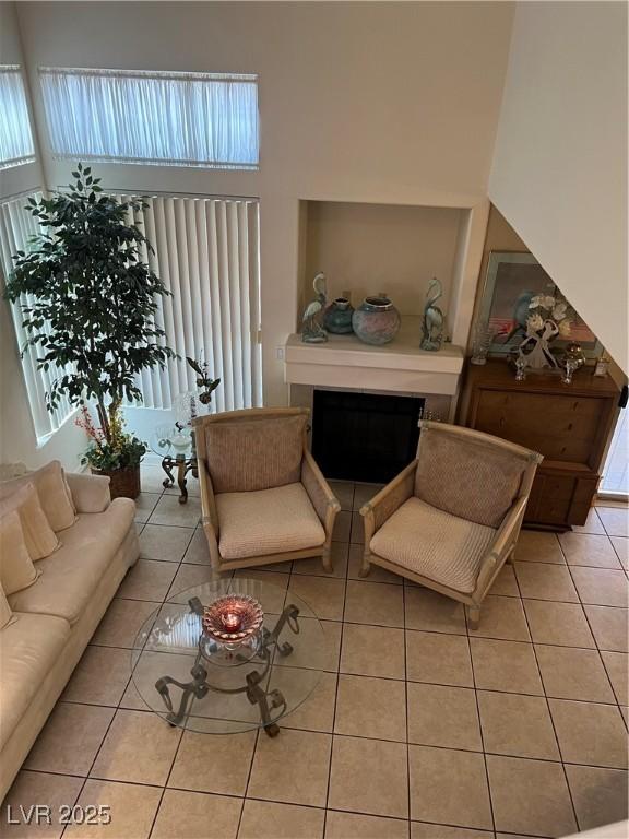 living room with tile patterned flooring, a high ceiling, and a fireplace