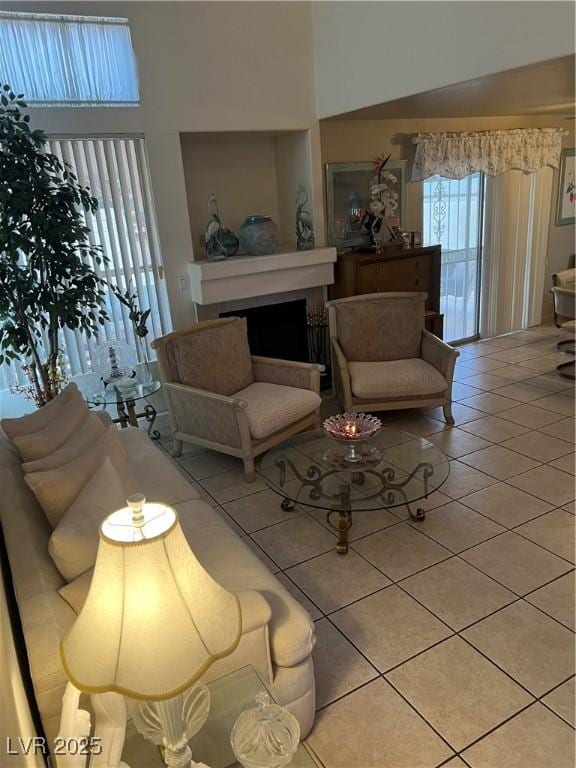 living room with a fireplace and light tile patterned flooring