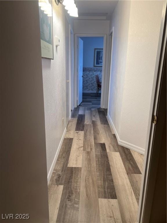 hall featuring a textured wall and dark wood-style floors