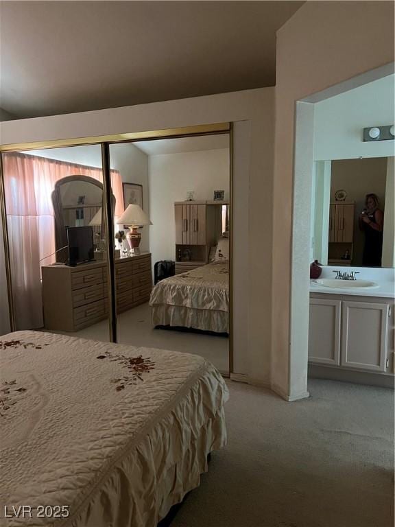 bedroom with light colored carpet and a sink