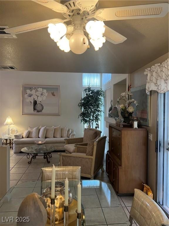 living area featuring ceiling fan, visible vents, a healthy amount of sunlight, and light tile patterned floors