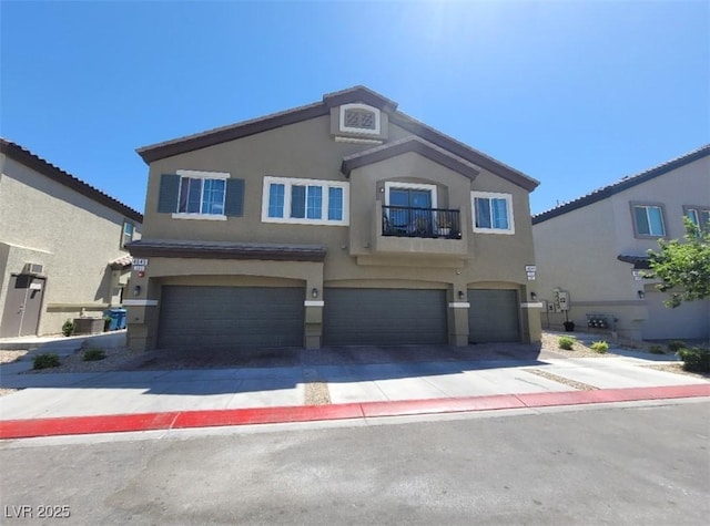 4645 Fuchsia Nights Ave Unit 103, North Las Vegas, NV 89084 - view of front of home featuring an attached garage, driveway, a balcony, and stucco siding