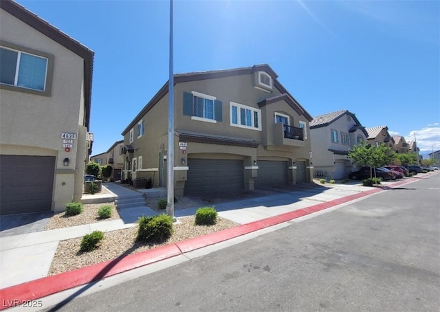 4645 Fuchsia Nights Ave Unit 103, North Las Vegas, NV 89084 - view of front facade with a residential view, an attached garage, and stucco siding