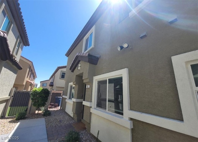 4645 Fuchsia Nights Ave Unit 103, North Las Vegas, NV 89084 - view of home's exterior with stucco siding and a gate