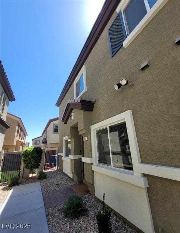 4645 Fuchsia Nights Ave Unit 103, North Las Vegas, NV 89084 - view of side of home with stucco siding and a gate