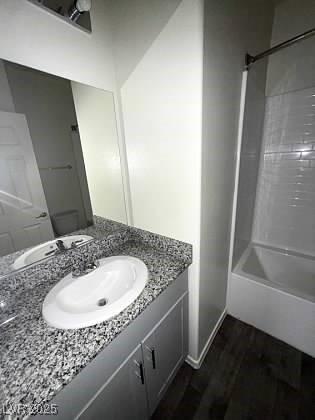 4645 Fuchsia Nights Ave Unit 103, North Las Vegas, NV 89084 - full bathroom with vanity, wood finished floors, and  shower combination