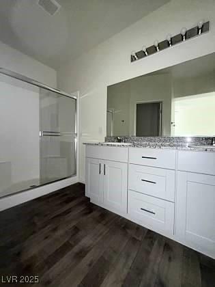 4645 Fuchsia Nights Ave Unit 103, North Las Vegas, NV 89084 - bathroom featuring a stall shower, wood finished floors, and double vanity