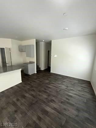 4645 Fuchsia Nights Ave Unit 103, North Las Vegas, NV 89084 - unfurnished living room featuring dark wood-style flooring and stairs