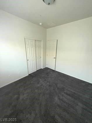 4645 Fuchsia Nights Ave Unit 103, North Las Vegas, NV 89084 - unfurnished bedroom with dark carpet and a closet