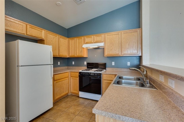 kitchen featuring freestanding refrigerator, under cabinet range hood, range with gas stovetop, and light brown cabinets