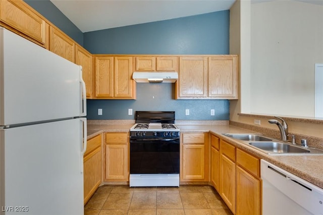 kitchen featuring light brown cabinetry, a sink, white appliances, under cabinet range hood, and vaulted ceiling