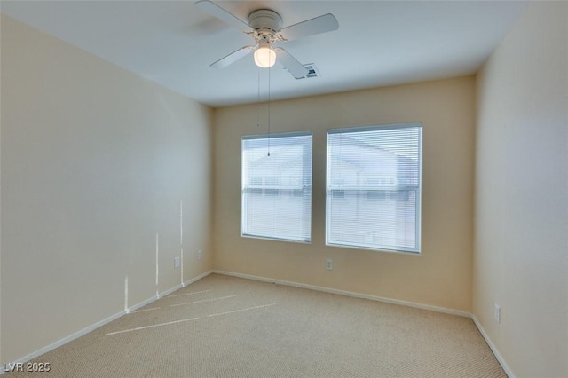 carpeted spare room with a ceiling fan, baseboards, and visible vents