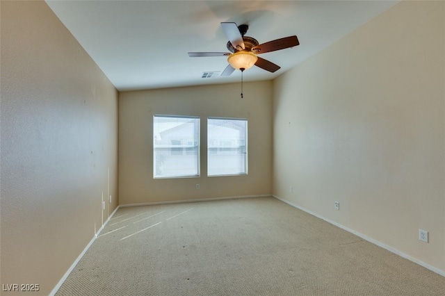 spare room with light carpet, visible vents, a ceiling fan, baseboards, and vaulted ceiling