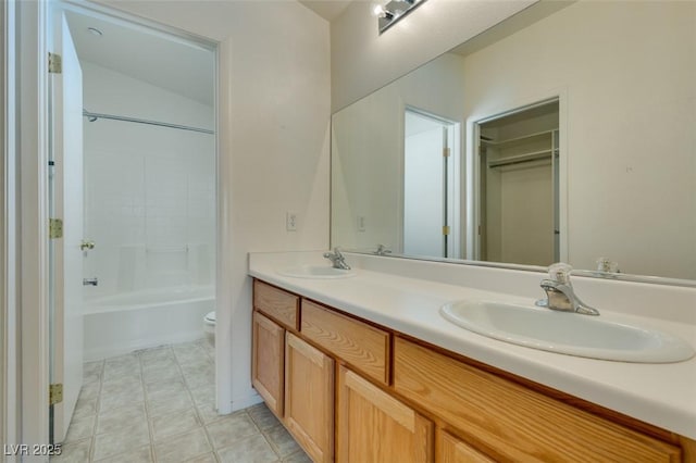 full bathroom with double vanity, toilet, shower / bath combination, and a sink
