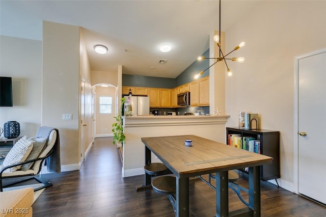 6576 Buster Brown Ave Unit 101, Las Vegas, NV 89122 - dining space featuring a chandelier, dark wood finished floors, baseboards, and lofted ceiling