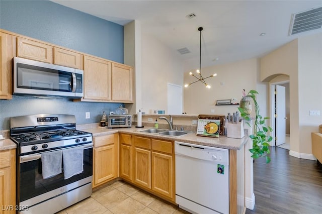 6576 Buster Brown Ave Unit 101, Las Vegas, NV 89122 - kitchen featuring stainless steel appliances, a sink, a peninsula, light brown cabinets, and light countertops