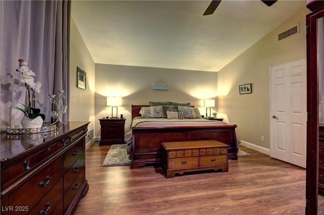 bedroom with dark wood-style flooring, ceiling fan, baseboards, lofted ceiling, and visible vents