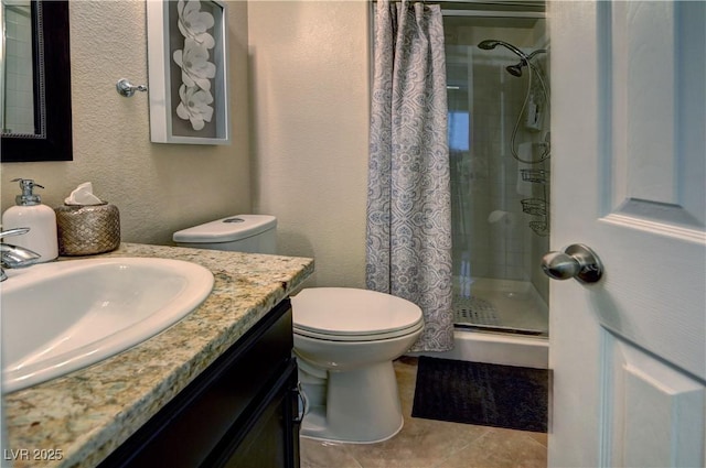 full bathroom with vanity, a textured wall, toilet, tile patterned floors, and a shower stall